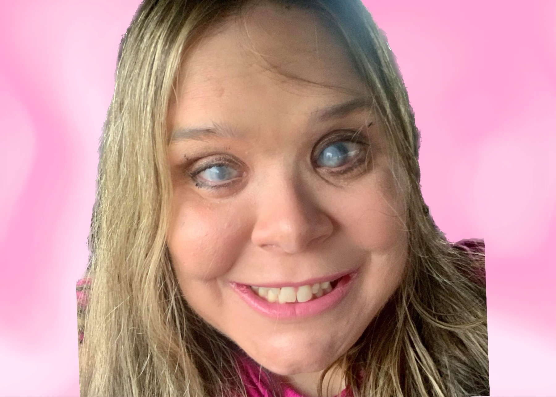 Photo of Amanda Selm. In the center of the photo is a blonde haired 36 year old girl with blue eyes and soft pink lips smiling.  A light pink background with soft white swooshes surround her.