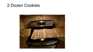 Pictured Four dozen cookies on a stove top.