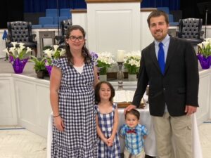 Left to right: DJ; daughter, Rachel; son, Daniel; and husband, Drew all stand at the front of a church wearing various shades of blue.